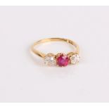 An 18ct gold and three stone ring, the central ruby flanked by two diamonds, the diamonds 4mm in