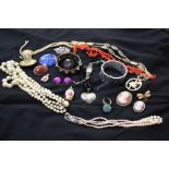 A quantity of costume jewellery to include assorted brooches, simulated pearls and other items