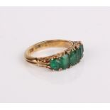 An 18ct gold and emerald five stone ring, 5.5g in total (af)