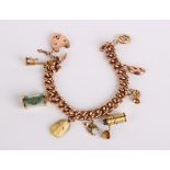 A 9ct gold charm bracelet with padlock clasp with assorted gold and gold coloured charms, 35.6g in