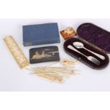 An early 20th Century Japanese matt black lacquered cigarette case, flatware, ivory counter with