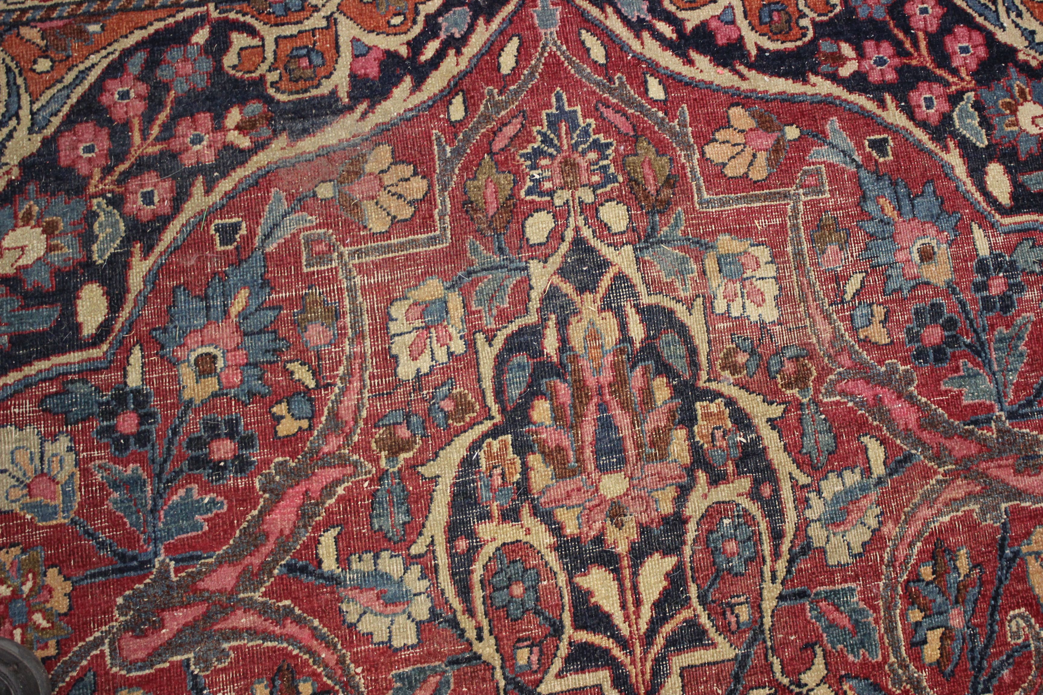 A Meshed carpet, the madder field with central indigo medallion within a floral border, bearing - Image 4 of 6