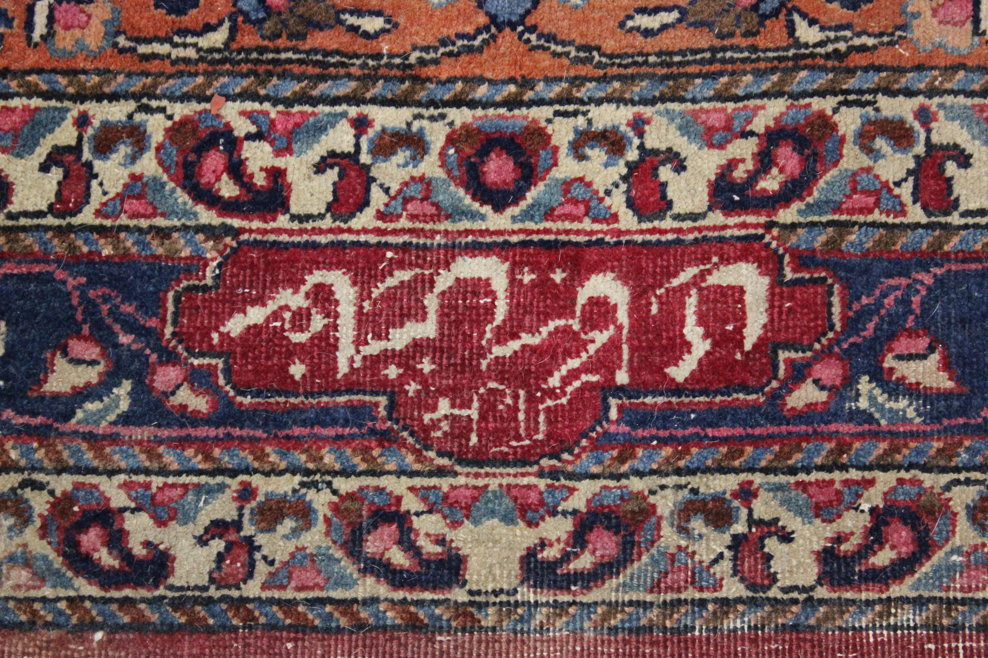 A Meshed carpet, the madder field with central indigo medallion within a floral border, bearing - Image 3 of 6