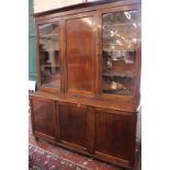 A George IV mahogany library bookcase with two hinged and one sliding door above a base with three