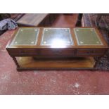 A coffee table with tooled surface and three frieze drawers