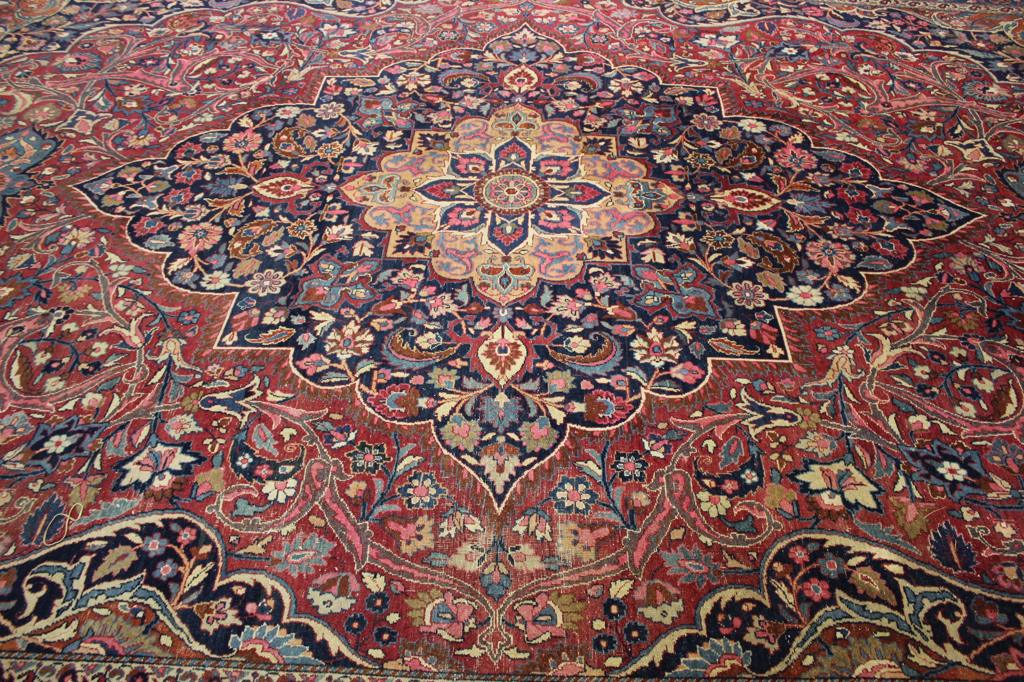 A Meshed carpet, the madder field with central indigo medallion within a floral border, bearing - Image 2 of 6