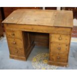 A pine headmasters desk with sloping fall and six drawers 92cm high, 122cm wide