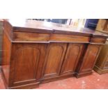 A Victorian mahogany inverted breakfront sideboard with a central cupboard flanked by single