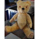 An Early 20th Century mohair teddy bear with amber eyes and articulated limbs .49cm. Remnants of a