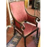 A Georgian mahogany library chair with shaped back on scroll arm supports and turned front legs