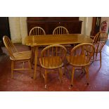An Ercol elm and beech dining table 136cm length and set of six hoop back dining chairs to include