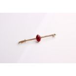 A gold and synthetic ruby set bar brooch, 3g in total