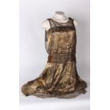 A reworked 1920s gold lamé dress, overlaid with metallic lace and embellished with gold bead