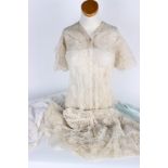 A full length cream antique lace reworked dress in need of restoration and repair; an early 20th