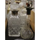 A pair of 'thistle' type decanters and stoppers, another pair of decanters and stoppers and a silver
