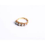 An Edwardian gold and half pearl five stone carved half-hoop ring with rose diamond points, with a