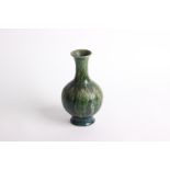 A Chinese Green Mottled Ground Bottle Vase with flared rim and stylized incised floral decoration,