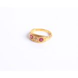 A late Victorian 18 ct gold, ruby and diamond gypsy ring centred with a small old-cut diamond,