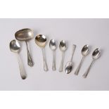 Silver teaspoons and a ladle