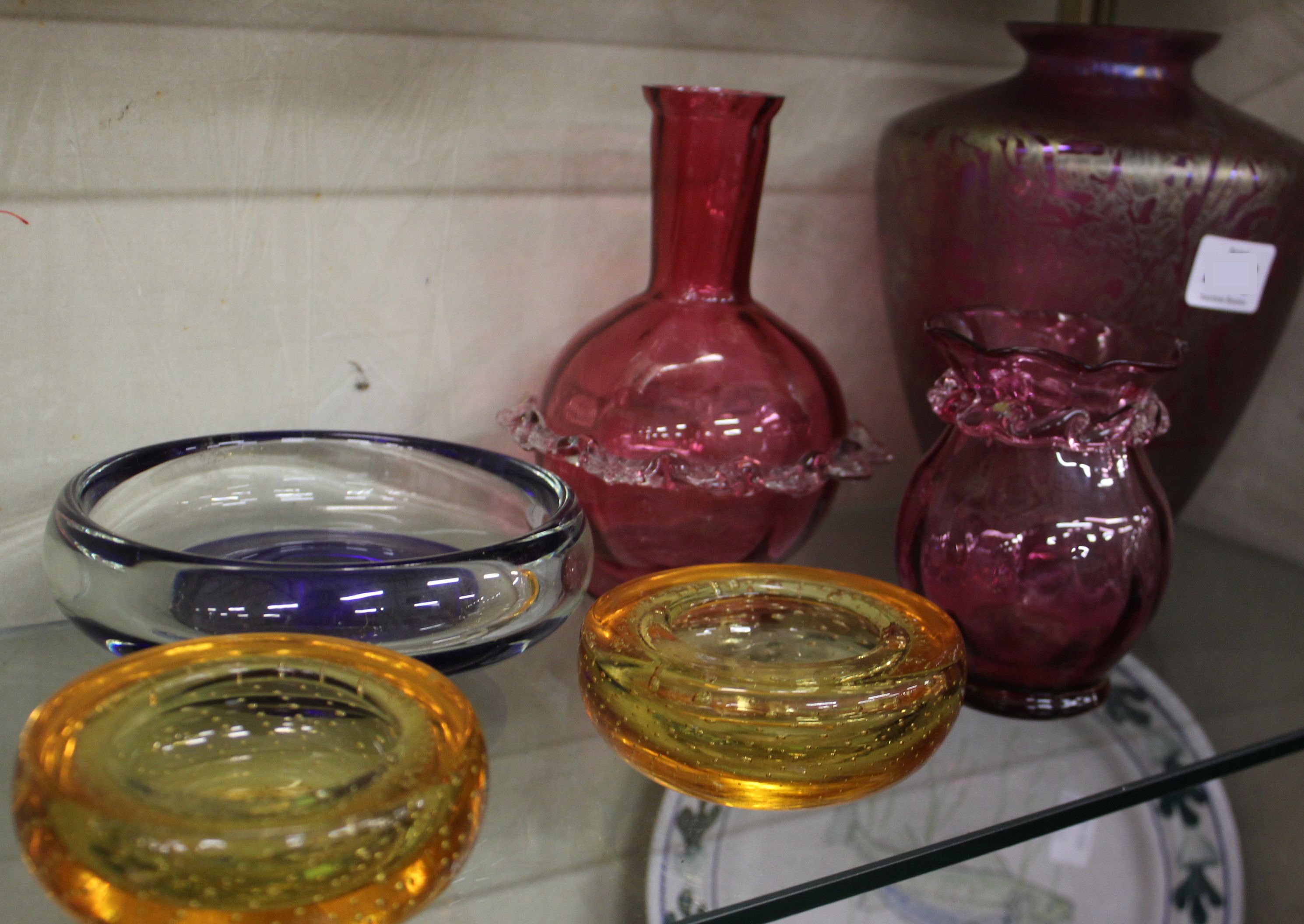 A cranberry glass vase and other coloured glassware