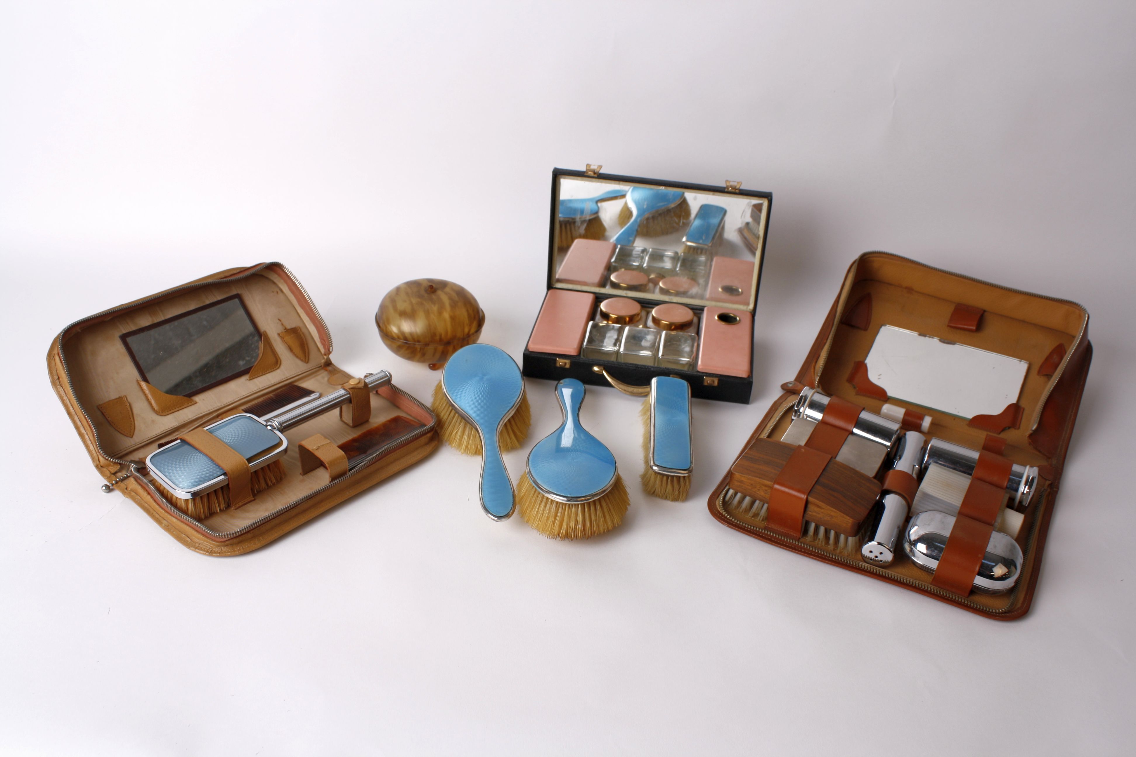 An Edwardian silver mounted heart dressing set, two enamelled silver hair brushes, a dressing case