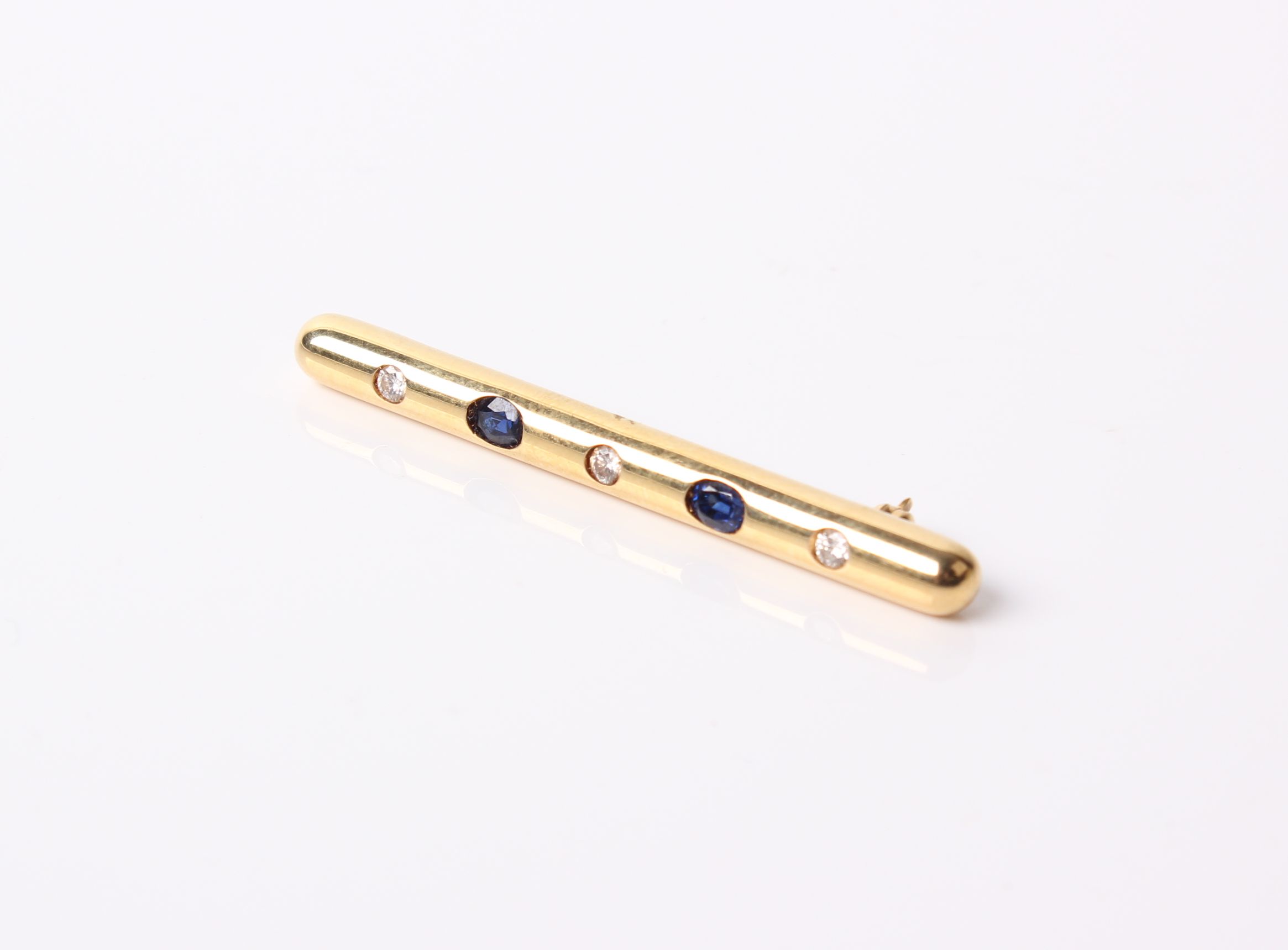 An 18 ct gold, sapphire and diamond five stone bar brooch the three round brilliant diamonds approx.