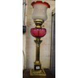 A Victorian style brass oil type table lamp with a cranberry glass reservoir