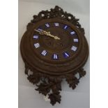 Late 19th century, profusely carved black forest wall clock with 8 day movement and enamel capitals