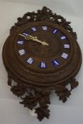 Late 19th century, profusely carved black forest wall clock with 8 day movement and enamel capitals