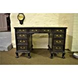 A late 19th century ebonised knee hole desk with carved decoration, leather inset having 9 drawers