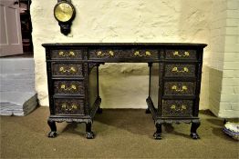 A late 19th century ebonised knee hole desk with carved decoration, leather inset having 9 drawers