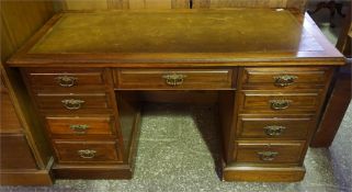 A late 19th century mahogany knee hole desk having 9 drawers with brass pulls and a leather insert