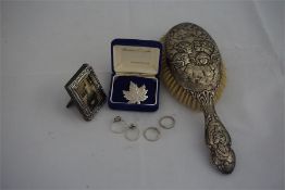 A silver backed hairbrush, silver photograph frame and 4 silver gem set rings with maple leaf brooch