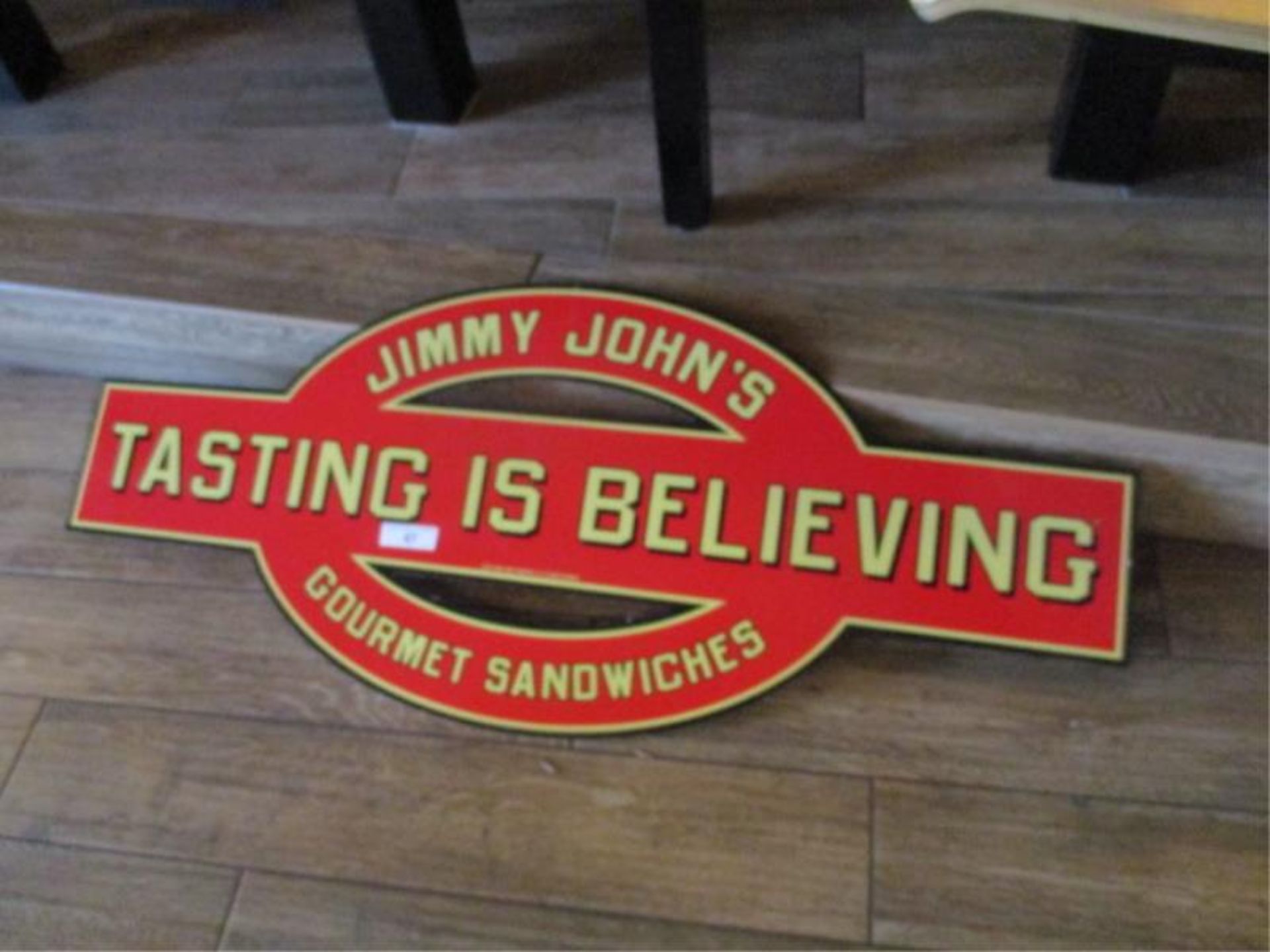 "Tasting is Believing" tin sign