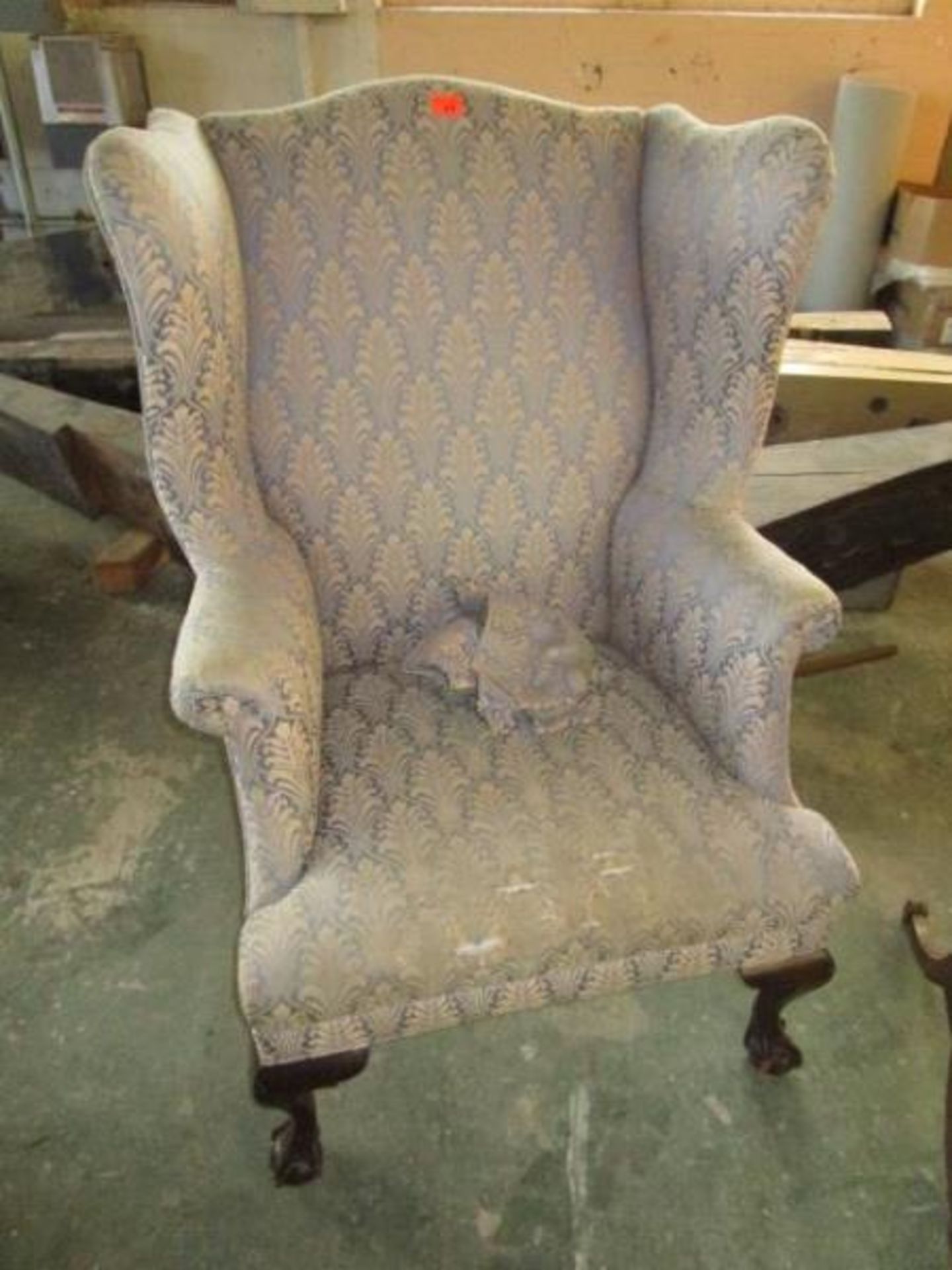 Wingback arm chair, blue and tan upholstery, ball and tall feet, tear in seat