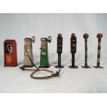 A small collection of early period lead models comprising two petrol pumps with hoses,