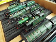 Approximately forty OO gauge model steam locomotives mounted on track plinths,