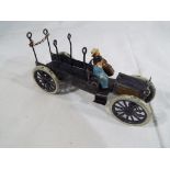 A early 20th century hand-painted metal model open lorry with two seated figures,
