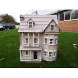 A good quality three storey wooden dolls house with furniture,