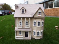 A good quality three storey wooden dolls house with furniture,