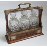 Victorian 3 bottle spirit Tantalus in oak and plated stand - locked with no key