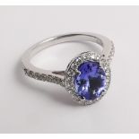 Good quality 18ct white gold modern tanzanite and diamond cluster ring - the central oval tanzanite