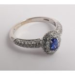 Sapphire and diamond cluster ring set with an oval sapphire of good colour with diamond surround