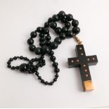 Graduated jet bead rosary with bog oak crucifix inset with coral suspended with 9ct gold suspension