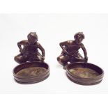 Pair of bronze figures of seated Chinese merchants with a cauldron,