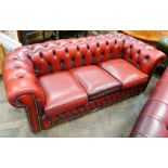 A 3 seater Chesterfield settee in buttoned red leather (faded)