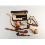 A collection of 19th century and later pipes and pipe cases in meerschaum with amber stems etc