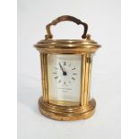 Miniature brass oval carriage clock by Mathew Norman of London. Swiss made, 6.