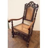 A Carolean style oak elbow chair with cross stretcher base,