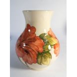 Moorcroft vase decorated with orange Hibiscus on a cream ground - height 25cm